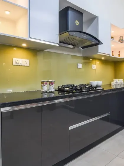 A close-up of the cooking area, showing the hob, chimney, and the easy-to-clean glass backsplash.