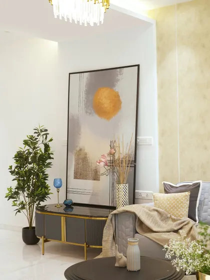 A modern black console with gold accents and a marble top, styled with a large piece of abstract art and a houseplant to create a sophisticated statement.