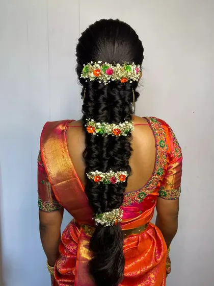 A highly detailed and voluminous braid, fully decorated with sections of colorful fresh flowers for a grand bridal look.