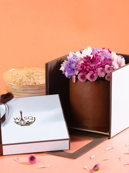 Introducing "Bloom," our signature mini cakes redefined with elegant fresh floral arrangements. This chocolate mini cake is topped with a beautiful bouquet of purple and white flowers, making it a stunning gift.
