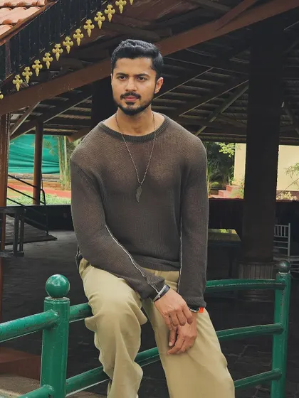 A more serious and thoughtful pose in a casual setting.