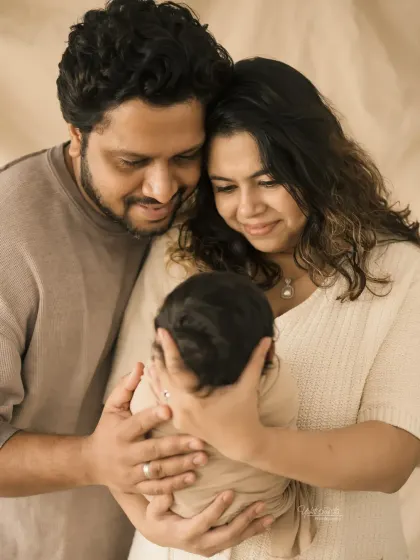 A unique angle showing the parents looking down at their newborn, a symbol of their love and protection.