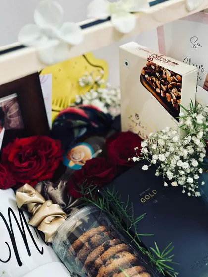 Another detailed shot of the anniversary gift hamper, highlighting the fresh red roses and baby's breath that add a touch of romance.