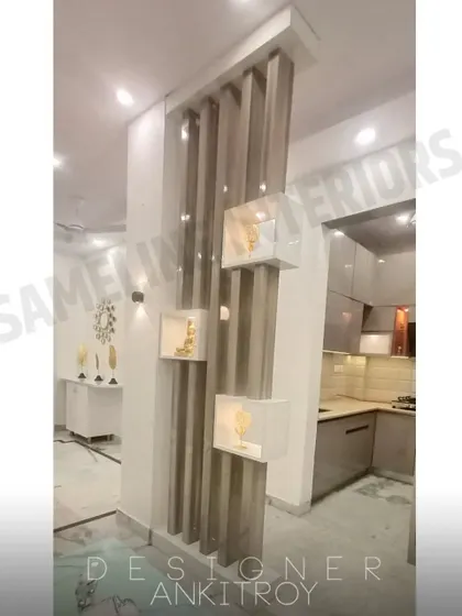 A floor to ceiling partition designed with vertical wooden slats and white display boxes for showcasing decor.