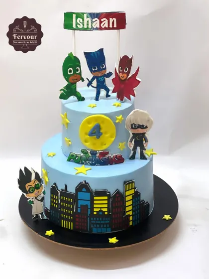 A two-tier PJ Masks cake featuring Catboy, Owlette, and Gekko ready for action. The cityscape design and character toppers make it an exciting cake for a young fan's 4th birthday.