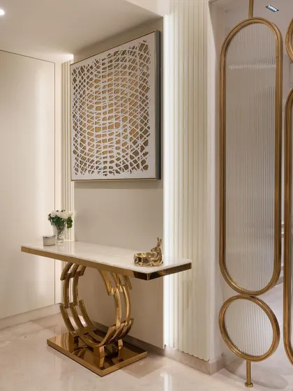 The foyer makes the first impression. We used a sculptural gold console table and abstract art to create a welcoming and glamorous entryway.