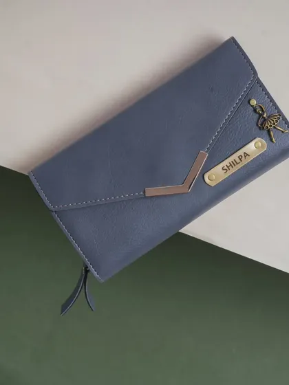 A close-up of the blue Nexa clutch, personalized with the name "Shilpa" and an elegant ballerina charm.