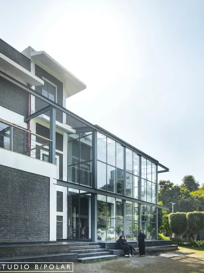 Another angle of the architectural intervention at the Media Monks campus, highlighting the contrast between the original dark brick building and the modern, light-filled glass extension we designed.