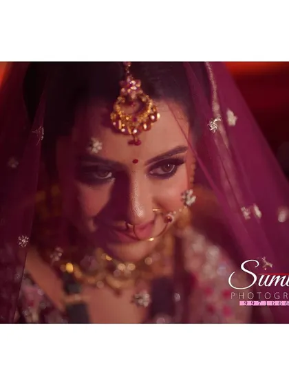 A close-up bridal portrait filled with emotion. The soft focus and dramatic lighting draw attention to her expressive eyes and gentle smile.