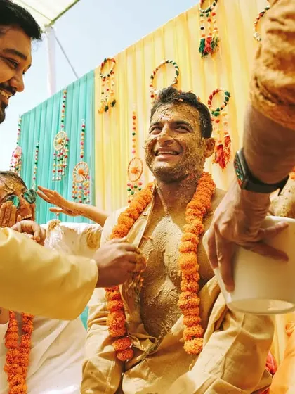 The groom's Haldi is just as lively. We focus on capturing the smiles and interactions with friends and family as they apply the turmeric paste, creating memories full of warmth and joy.
