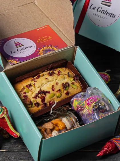 Our budget-friendly Diwali Mini Hamper. It includes a Mawa Pistachio cake, a jar of dry fruits, and our popular cracker chocolates, all packed in a lovely box.
