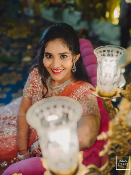 A sweet portrait of the bride at her reception, her happy smile framed by the warm glow of decorative lamps.