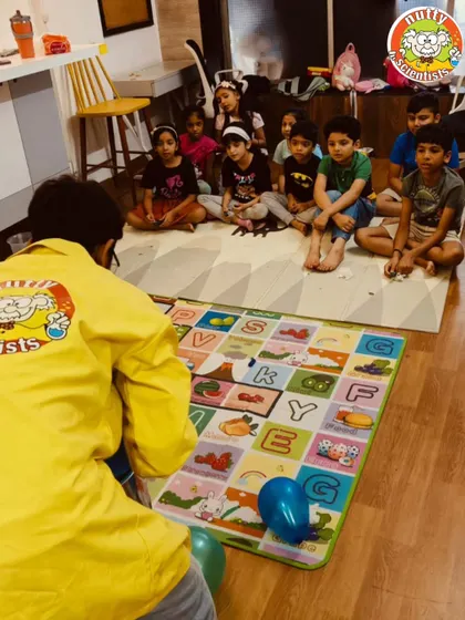 A professor leads a group activity on a colorful mat, keeping the kids engaged with a fun, educational game.