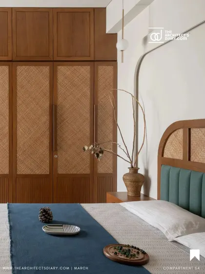 The master bedroom in Oatmeal House is a blend of clean aesthetics and warm textures. We designed a custom wardrobe with woven cane panels and a bed with a teal upholstered headboard, creating a tactile and visually soothing environment for rest and relaxation.