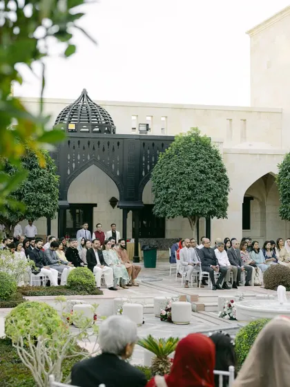 A wide shot of the guests seated for Moin and Roha's ceremony, showing the peaceful and elegant atmosphere of the Ismaili Centre's courtyard.
