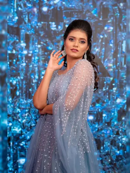 A portrait that captures a dreamy, ethereal vibe. The sparkling details on this blue gown shimmer against the crystal-like background, creating a magical effect.