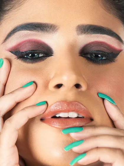 An extreme close-up focusing on the detailed eye makeup. This shot highlights the blended red and black eyeshadow and the precise winged liner, perfect for beauty campaigns.
