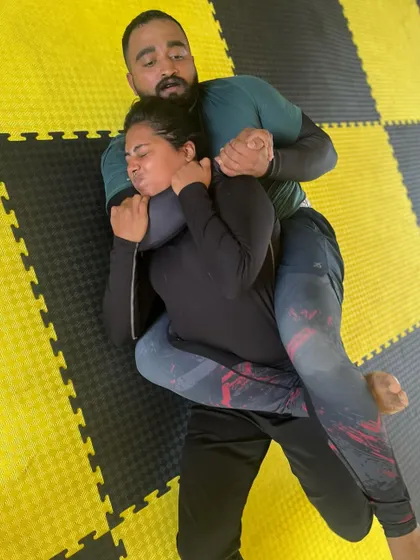 A student applying a rear naked choke. The grimace on his opponent's face shows the effectiveness of the technique.