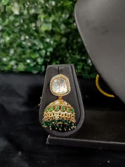 A simple and elegant jhumka with a single polki stone and a green beaded dome. This rental piece is perfect for a minimalist look.