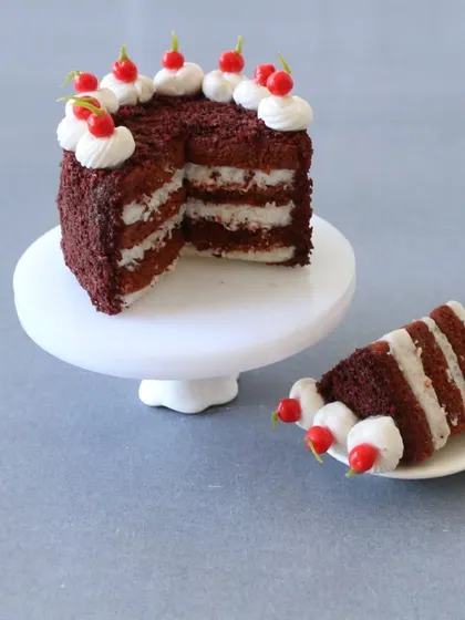 A close-up of the layered red velvet cake, showing the perfect slice and creamy frosting.