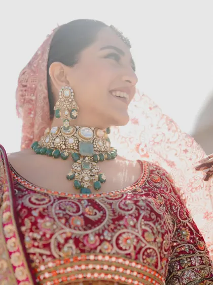 A radiant bride, her smile as bright as the sun. This close-up captures her happiness and the beautiful details of her wedding look.