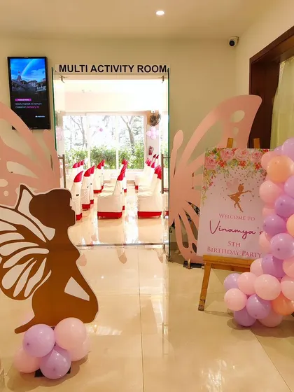The entrance to Vinamya's party, featuring large butterfly wing silhouettes and a welcome sign.