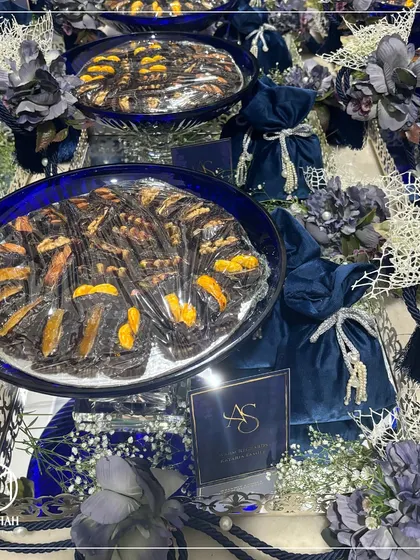 My Azure Crystal Bowl Hampers, arranged for a grand event. The deep blue crystal bowls filled with gourmet dates and paired with velvet potlis create a stunning visual and a luxurious guest gift.