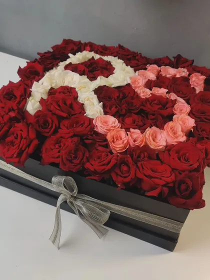 A personalized flower box with the initial 'R' created using a mix of white, pink, and red roses. I can customize these arrangements with any letter or design.