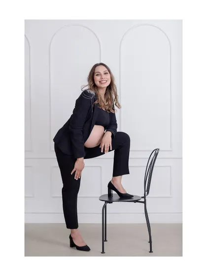 A confident and stylish maternity fashion portrait, showcasing a modern take on pregnancy photos.