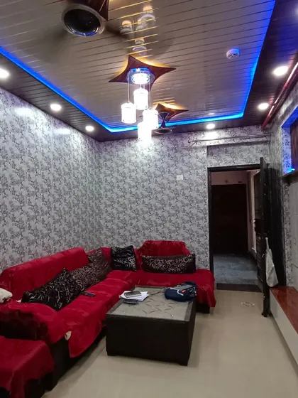 A full view of a living room after a budget-friendly renovation using PVC panels on the ceiling and walls.