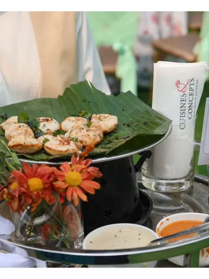 A tray of Spicy Kuzhi Paniyaram, a South Indian specialty, served on a banana leaf for an authentic touch.