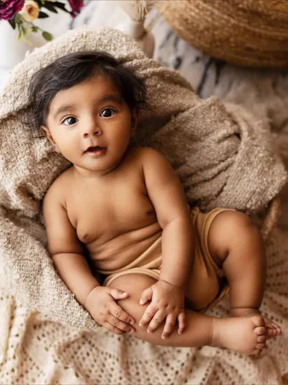 A chubby and adorable baby enjoying some quiet time in a basket. A simple, sweet, and timeless portrait.