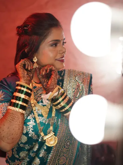 A getting-ready shot of the reception bride, putting on her earrings. The makeup is soft yet defined.
