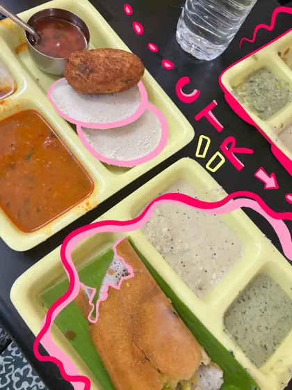 A classic CTR breakfast in Malleshwaram. The pink doodles highlight the delicious dosa and idlis on the plate.