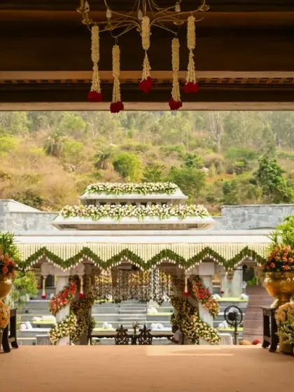 The grand entrance to the mountain-view wedding, with a carpeted path flanked by large brass urns filled with flowers.