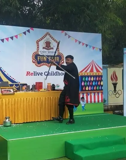 The magic wand is a classic for a reason. Here I am performing the dancing cane illusion, a graceful and mystifying trick that works beautifully on an outdoor stage.