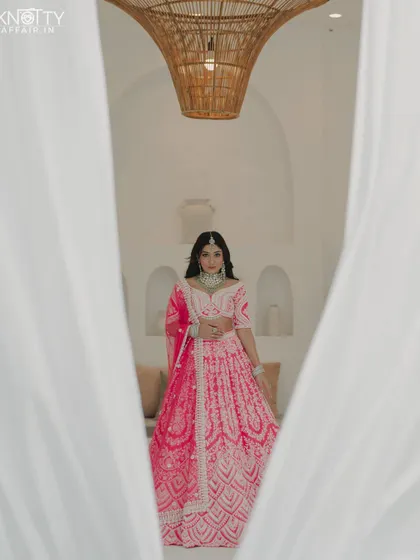 An artistic bridal portrait framed by white curtains. This creative composition adds a sense of mystery and elegance.