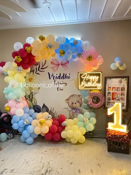 A full view of the colorful teddy bear first birthday, including a framed photo collage of the baby's first year.