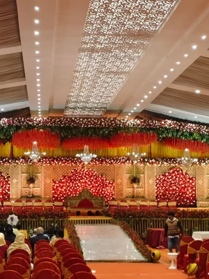 We transform grand venues into breathtaking scenes for your special day. This wedding reception setup features a magnificent floral stage, dramatic lighting, and seating for hundreds of guests, all meticulously planned to create a royal and elegant atmosphere.