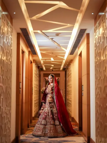 A full-length portrait of the bride in a long, elegant corridor. This shot showcases her entire outfit and creates a sense of solitude and anticipation.