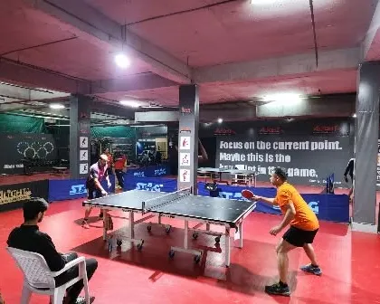 Another angle of the tournament in full swing. The setup includes professional barriers and umpire seating for each table.