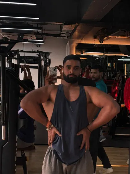 Hard work pays off. A member showing off his impressive back and shoulder development after a tough workout.