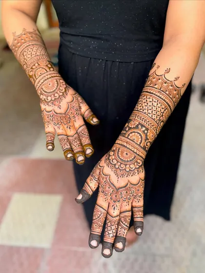 An alternate angle of Kavitha's baby shower mehendi, highlighting the intricate mandala work on the palms.