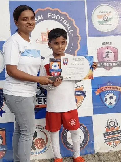 A coach presents a certificate and trophy to one of our players at an MFA event. This formal recognition is an important part of a young athlete's development and motivation.
