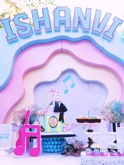 A full view of the music-themed dessert table, showcasing the layered pastel backdrop, the custom cake, and an array of sweet treats ready for the little guests.