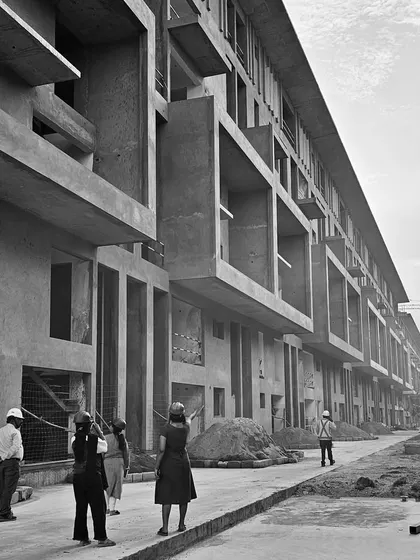 A site visit to our "Earth & Sky" housing project in Bangalore during construction. This black and white photo highlights the strong geometric forms of the concrete structure and the deep, recessed balconies that will become private gardens.