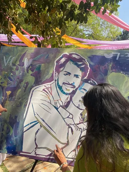 A guest adding the final touches to the couple's portrait. It's a process of layering colors and memories.