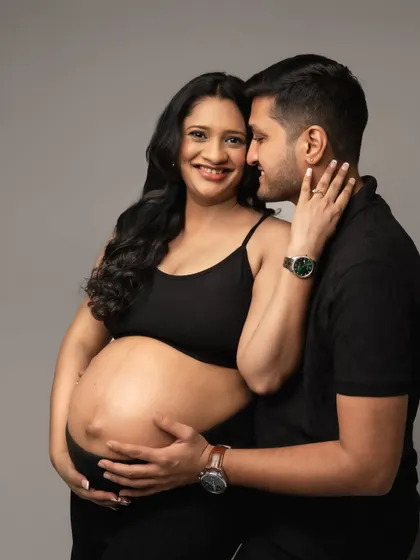 A close-up shot that captures the intimacy and affection between the expecting parents.