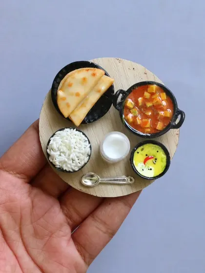 A miniature rice and chapati combo, a simple yet comforting meal recreated in clay.