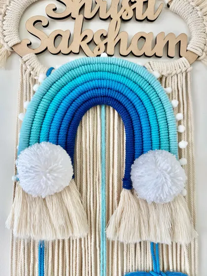 A detailed shot of the blue ombre rainbow and fluffy white pom-poms.